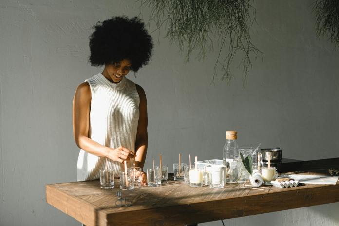 cheerful black woman making candles