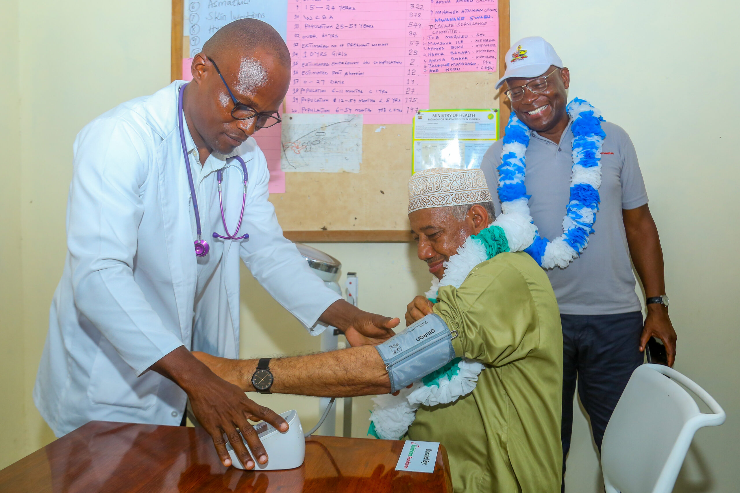 Dr. Isaac Njama (left) monitors Lamu County Governor, Issa Timamy (centre) as Safaricom Foundation Joe Ogutu looks on during the handover of maternity equipment at Siyu Dispensary in Lamu County.