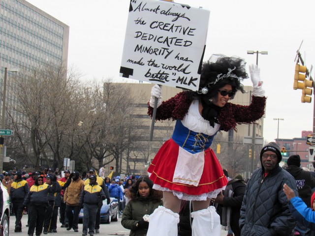 A woman on stilts waves to the crowd during the 17th annual Martin Luther King Jr. Day parade. (Photo by Briahnna Brown)