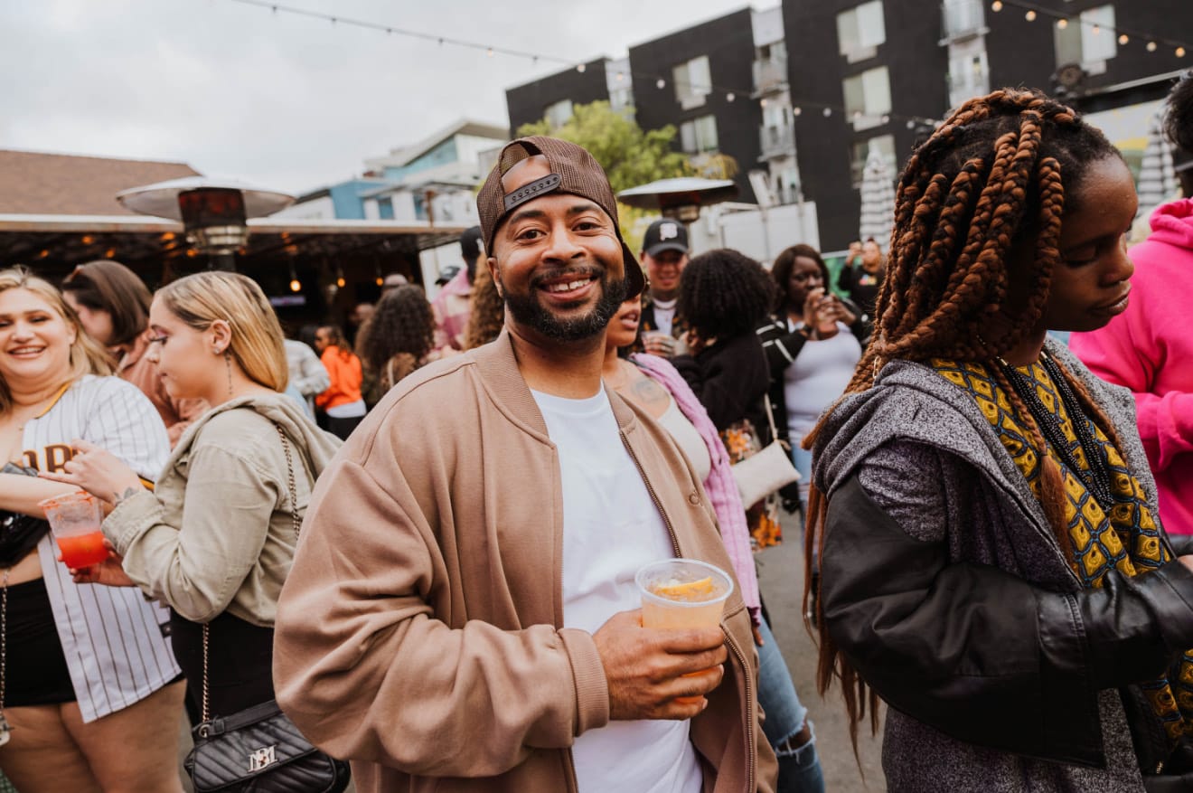 Guests smiling and mingling at an outdoor daytime block party