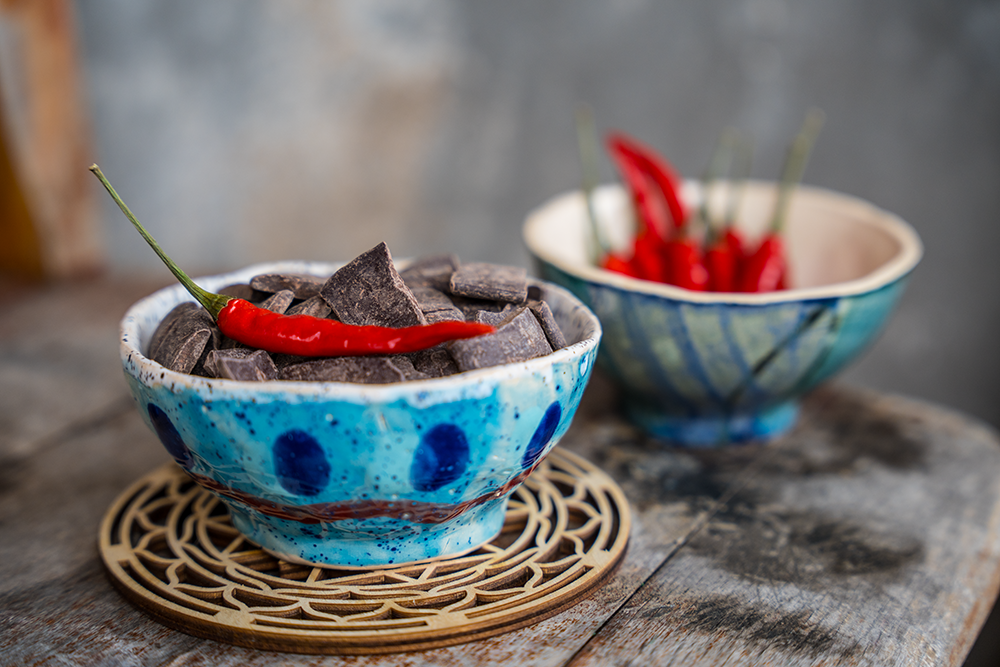 Zwei blaue Schalen mit Kakao und Chili Schoten