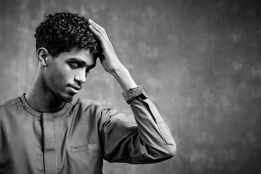 Afrikanischer junger Mann mit lockigem Haar, und traditionellen afrikanischem Hemd, das Bild ist schwarz-weiß