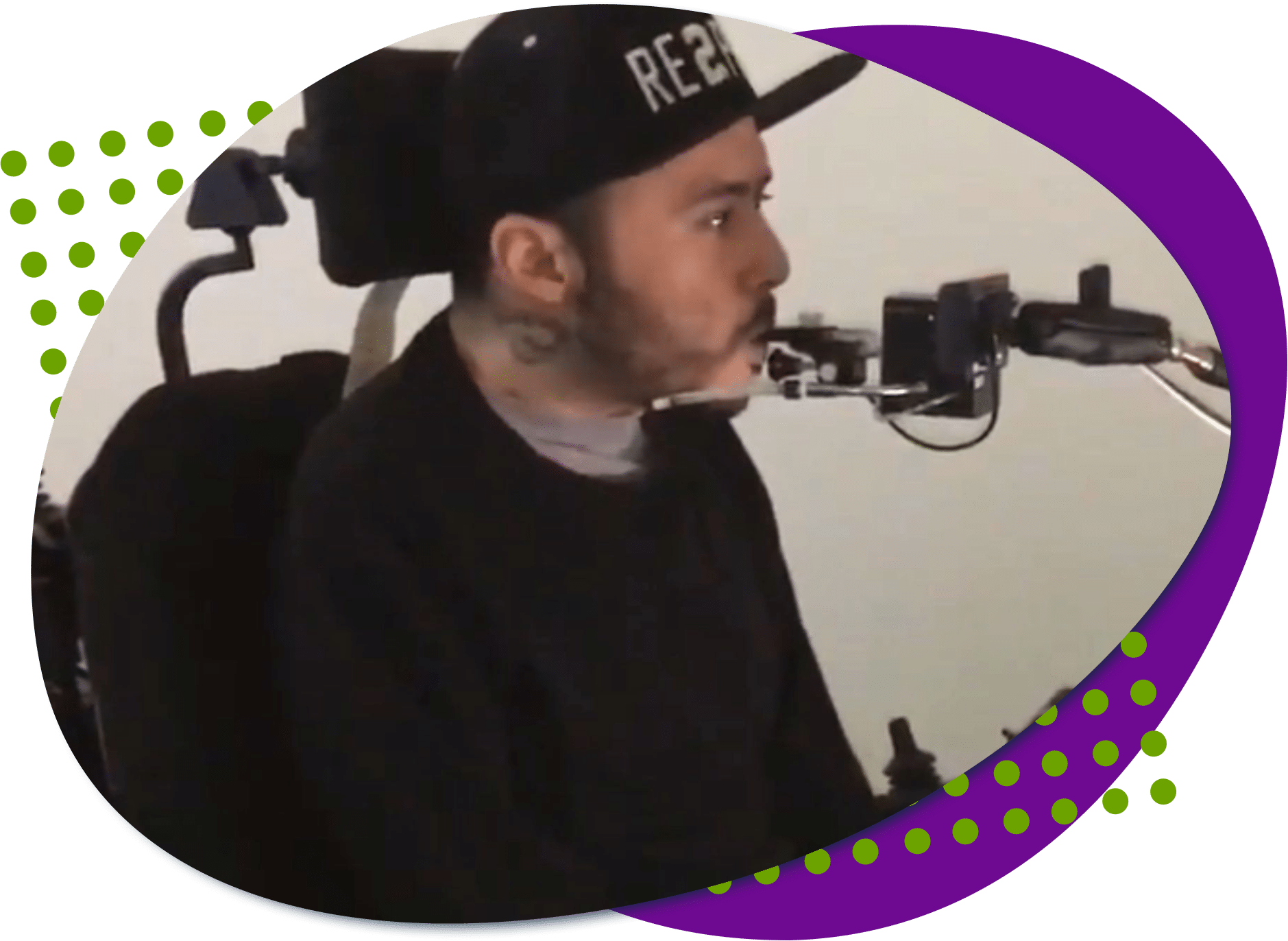 Walter is wearing black and is in a wheelchair, he is blowing into a quadstick.