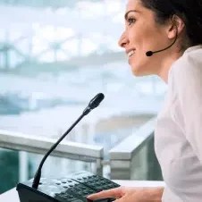 Femme parlant à un micro de sonorisation