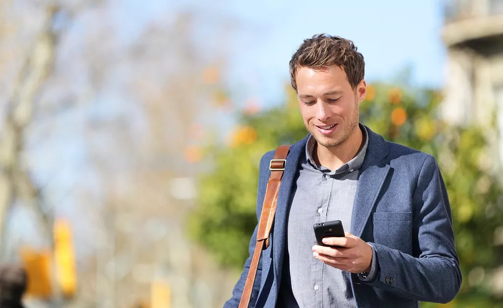 Homme avec téléphone mobile à la main pour appeler et recevoir ses appels téléphoniques professionnel même en déplacement.