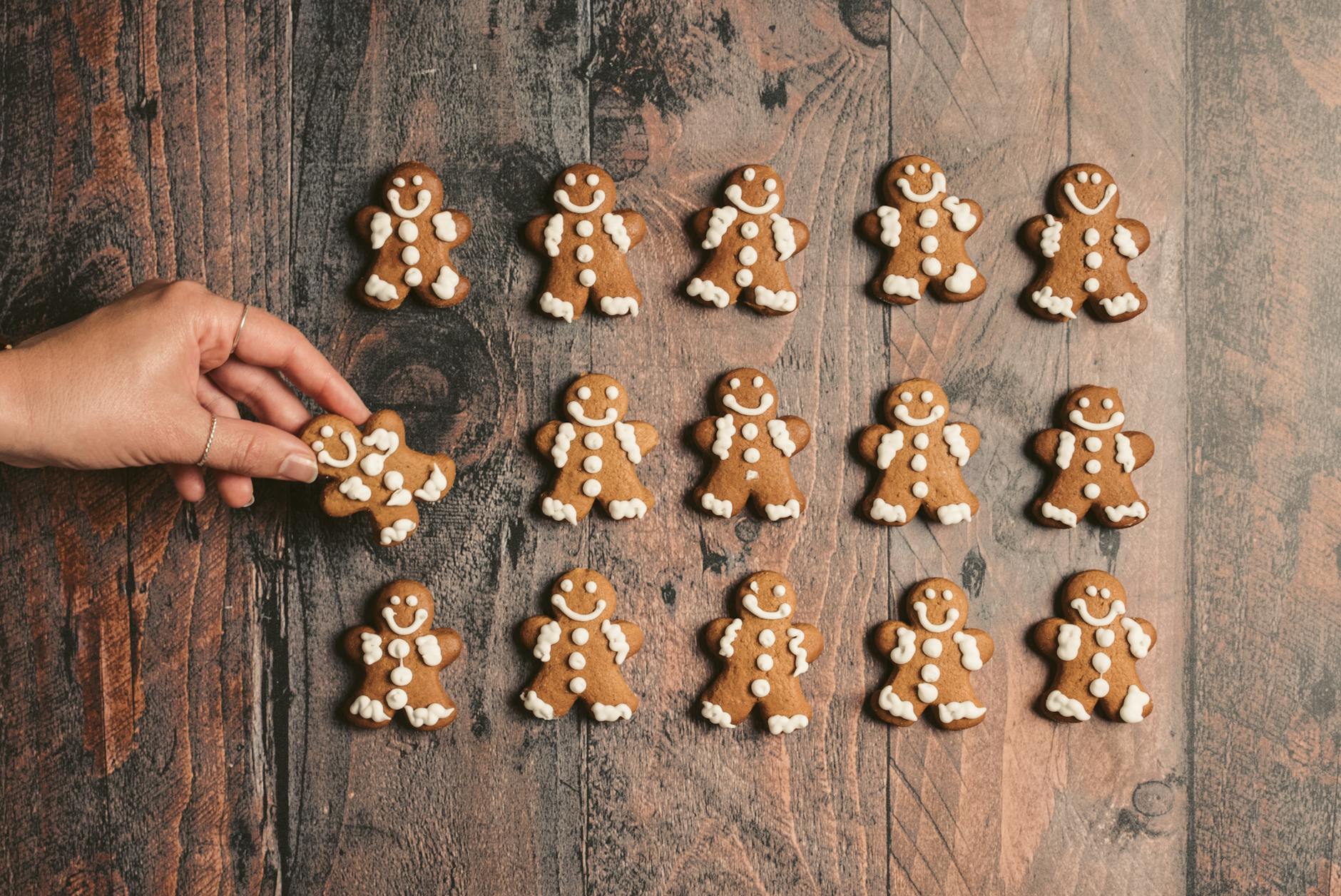 person putting cookie on wooden surface