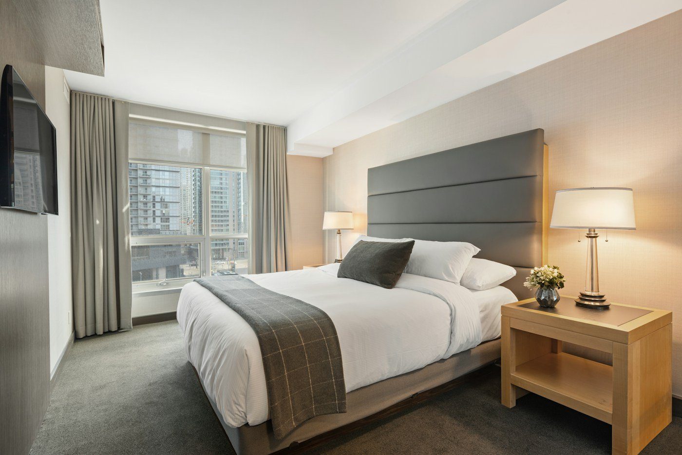 Neatly made bed in a quiet, dimly lit bedroom