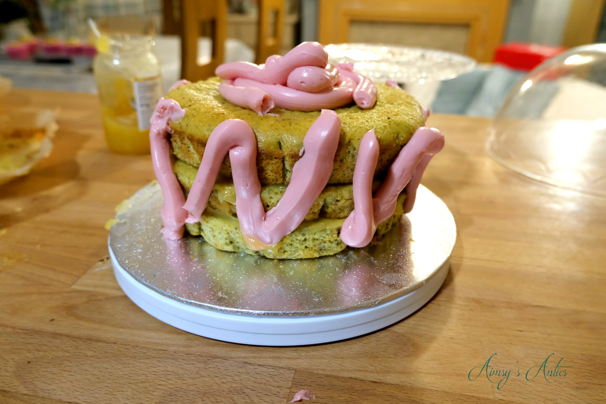 Adding the swiss meringue butter cream to the pistachio and rose cake for the crumb coat