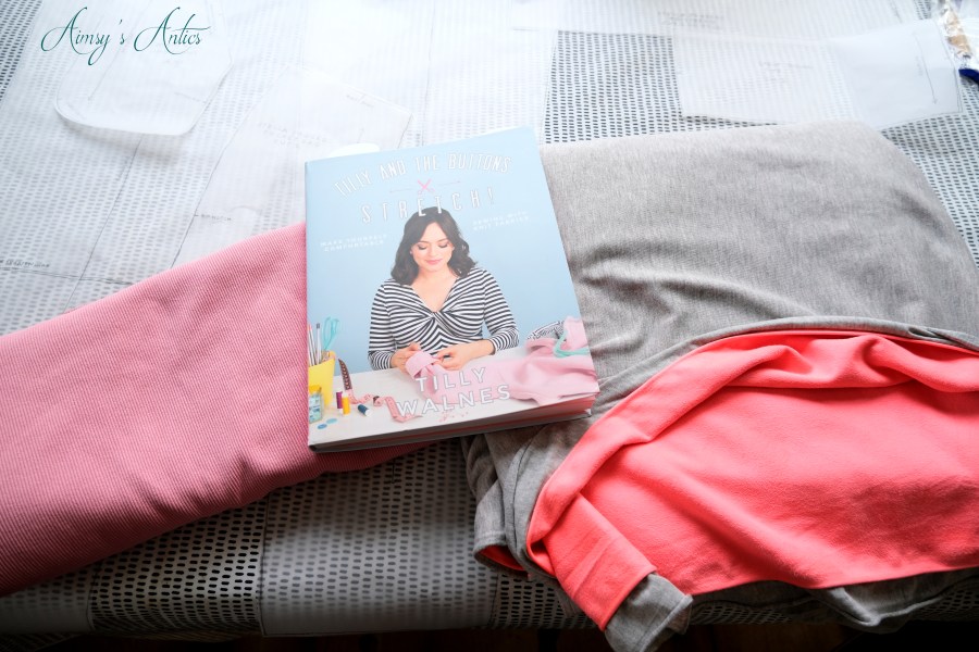 Items for how to make joggers, including the Tilly & the Buttons Stretch book and fabric of choice
