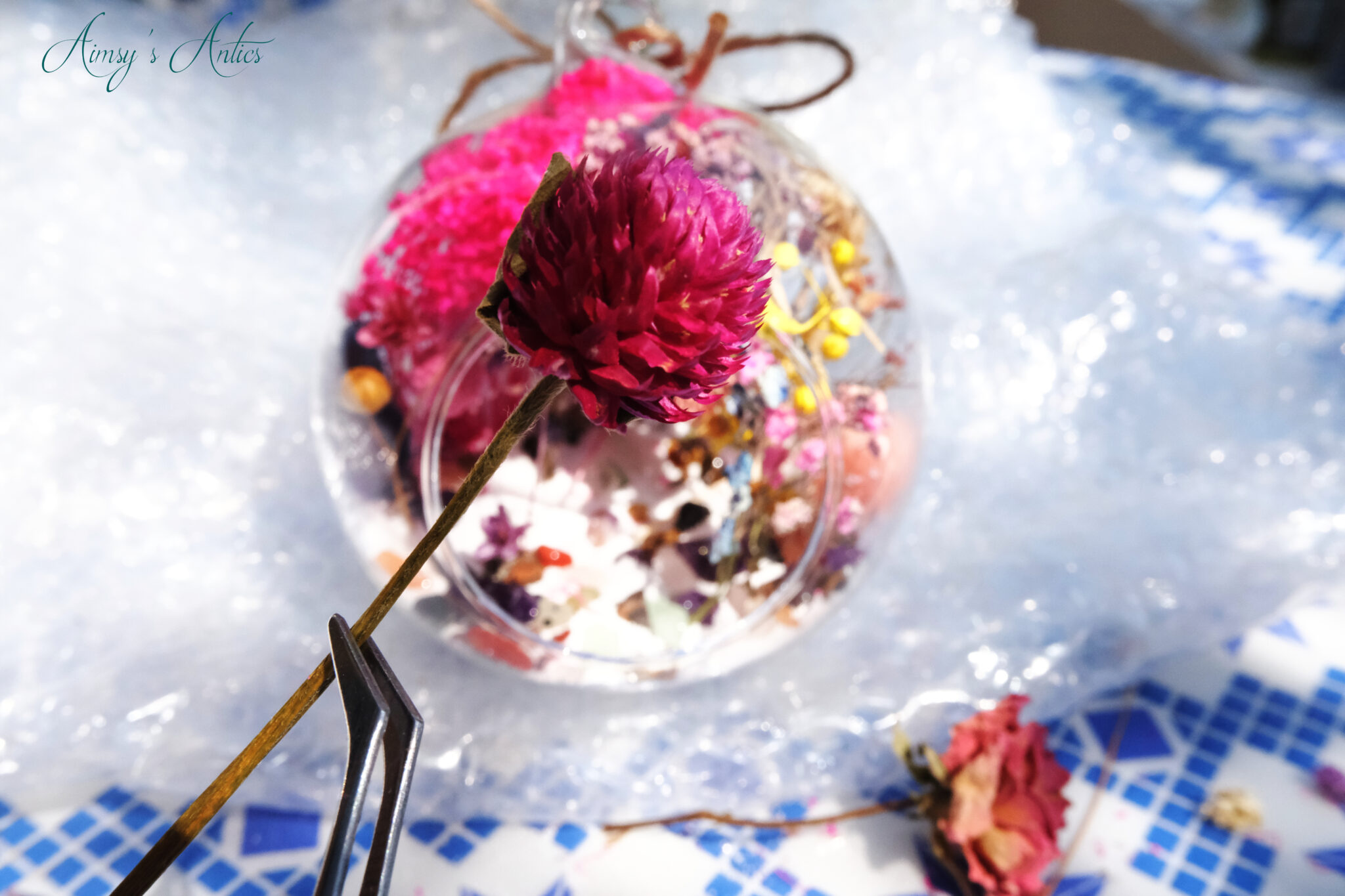 Adding dried flowers to the terrarium globe