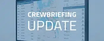 Desktop monitor displaying the CrewBriefing interface with a text overlay that reads "CrewBriefing Update," featuring flight planning details and map visuals.