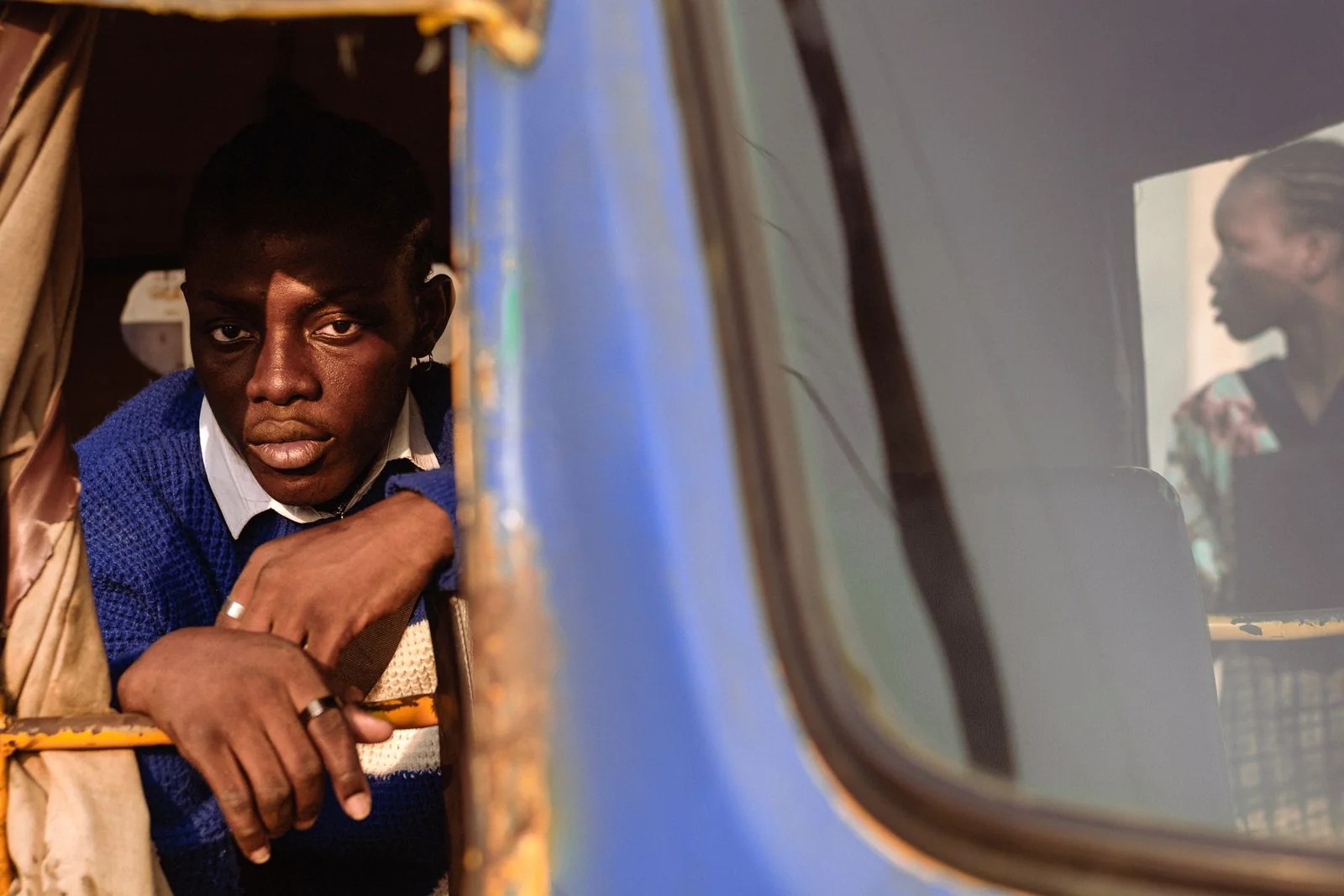 A thoughtful Nigerian man looking through the window of a Lagos bus