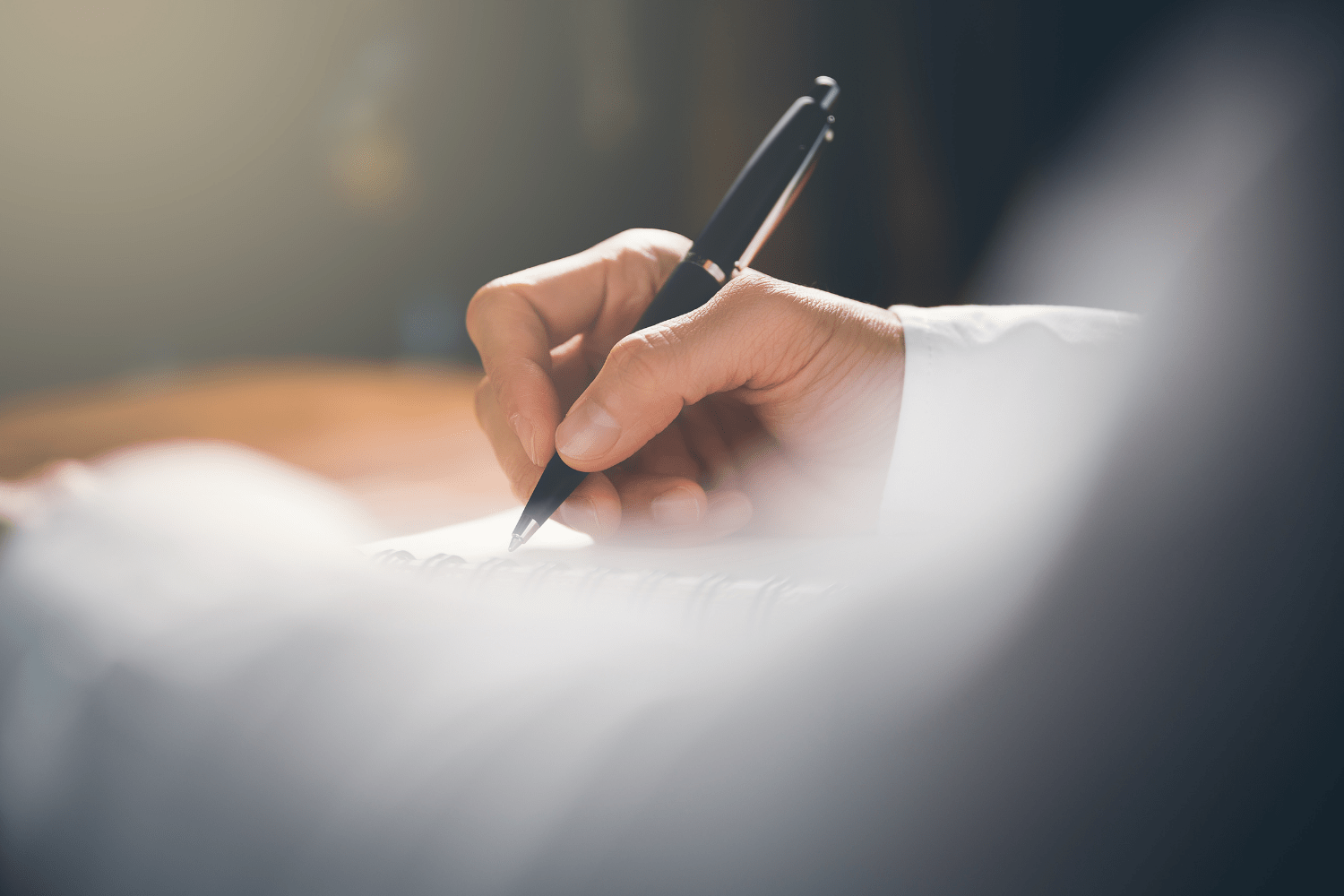 A close-up of a hand holding a pen about to write.