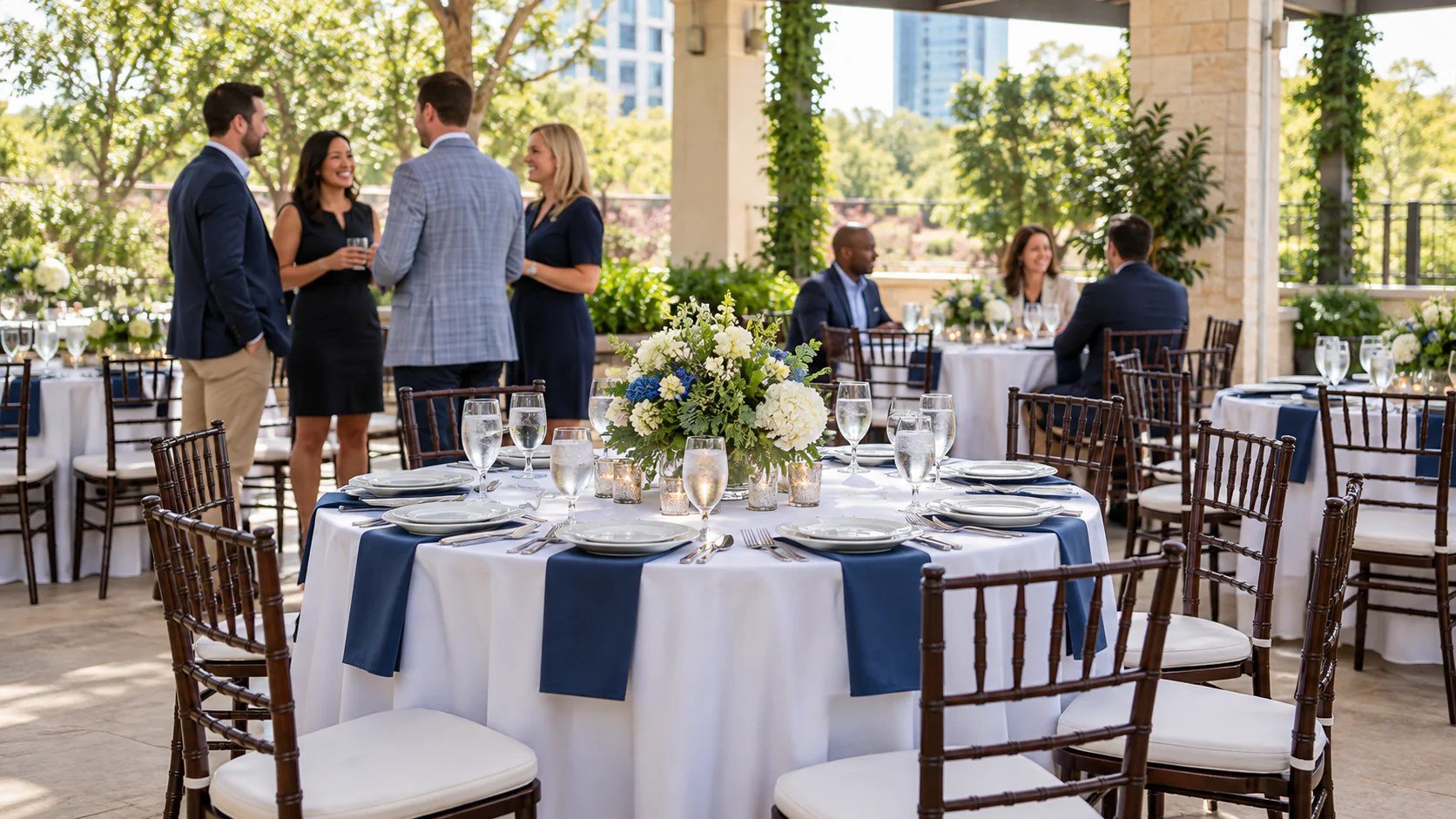 Corporate luncheon setup with round tables, white linens, navy accents and chairs