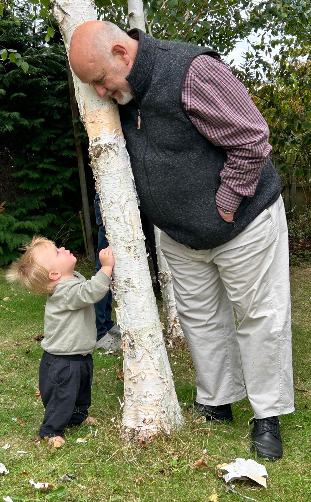 Ledger looking up at Alan, in front of a silver birch tree.