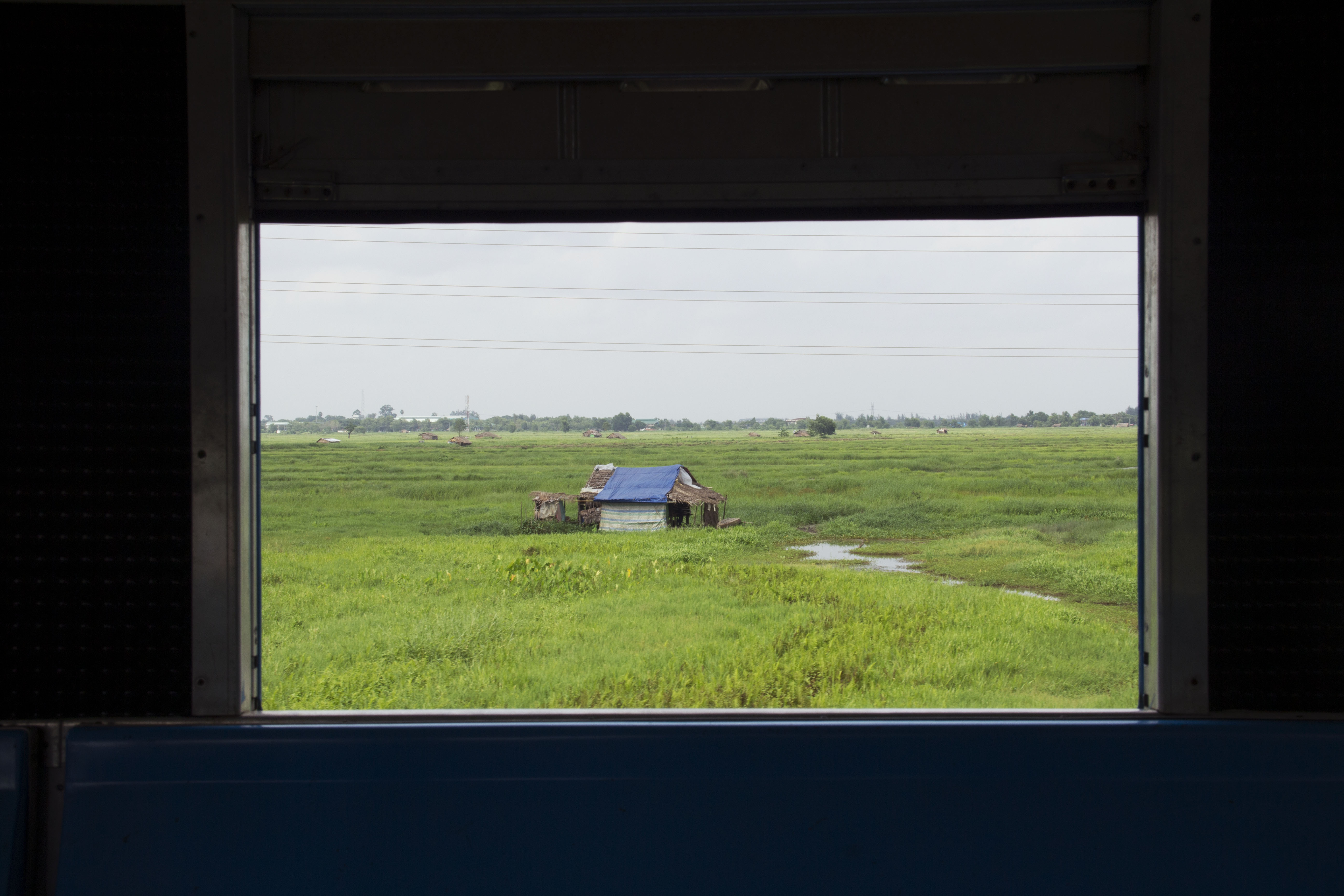 Hut in the middle of a vast green field in one of the villages along Circular Train route.