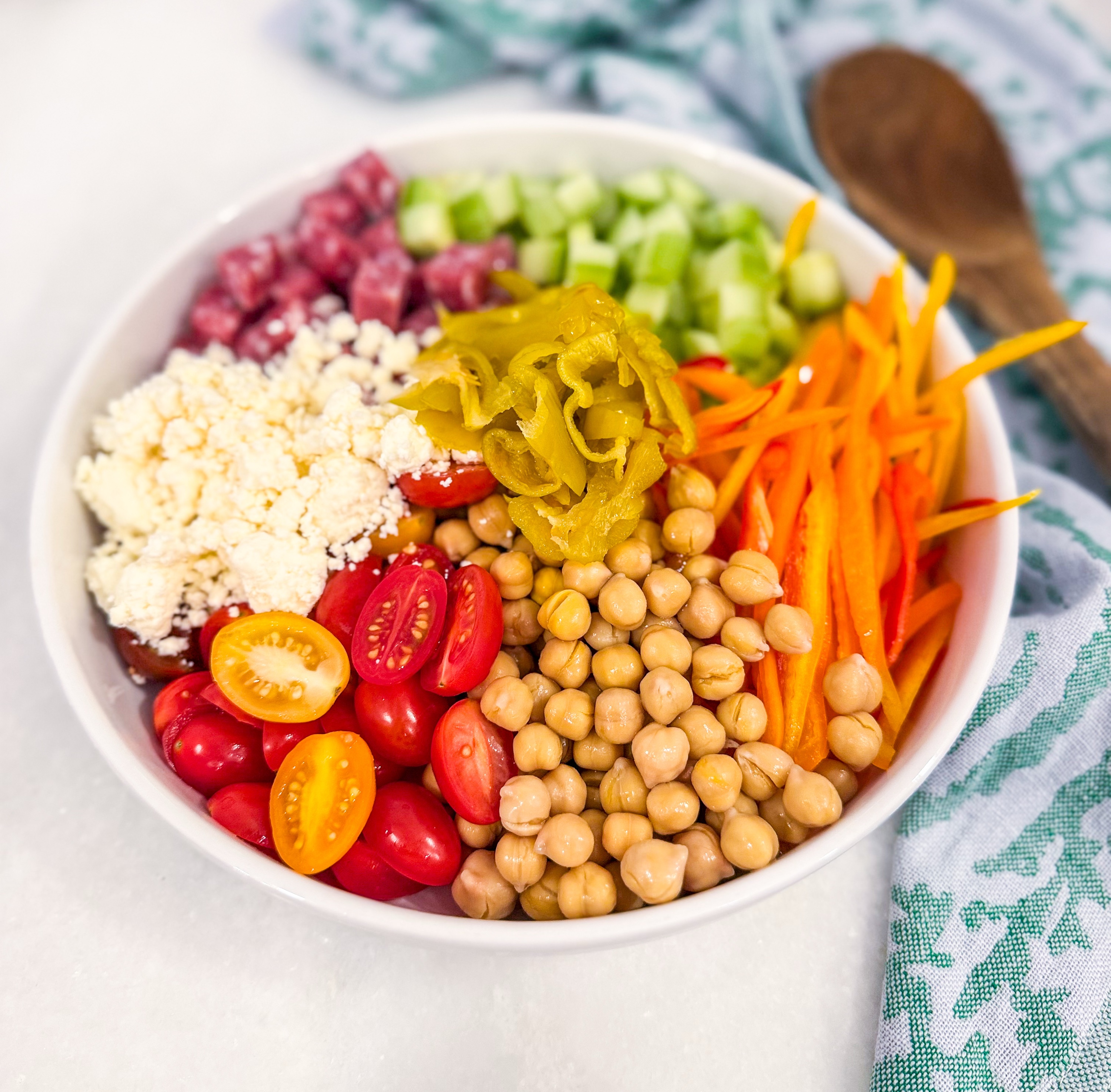 Eat Fit Mediterranean Micro Chop Salad - Cucumbers, tomatoes, sweet peppers, chickpeas, feta, salami, and banana peppers tossed with olive oil and red wine vinegar