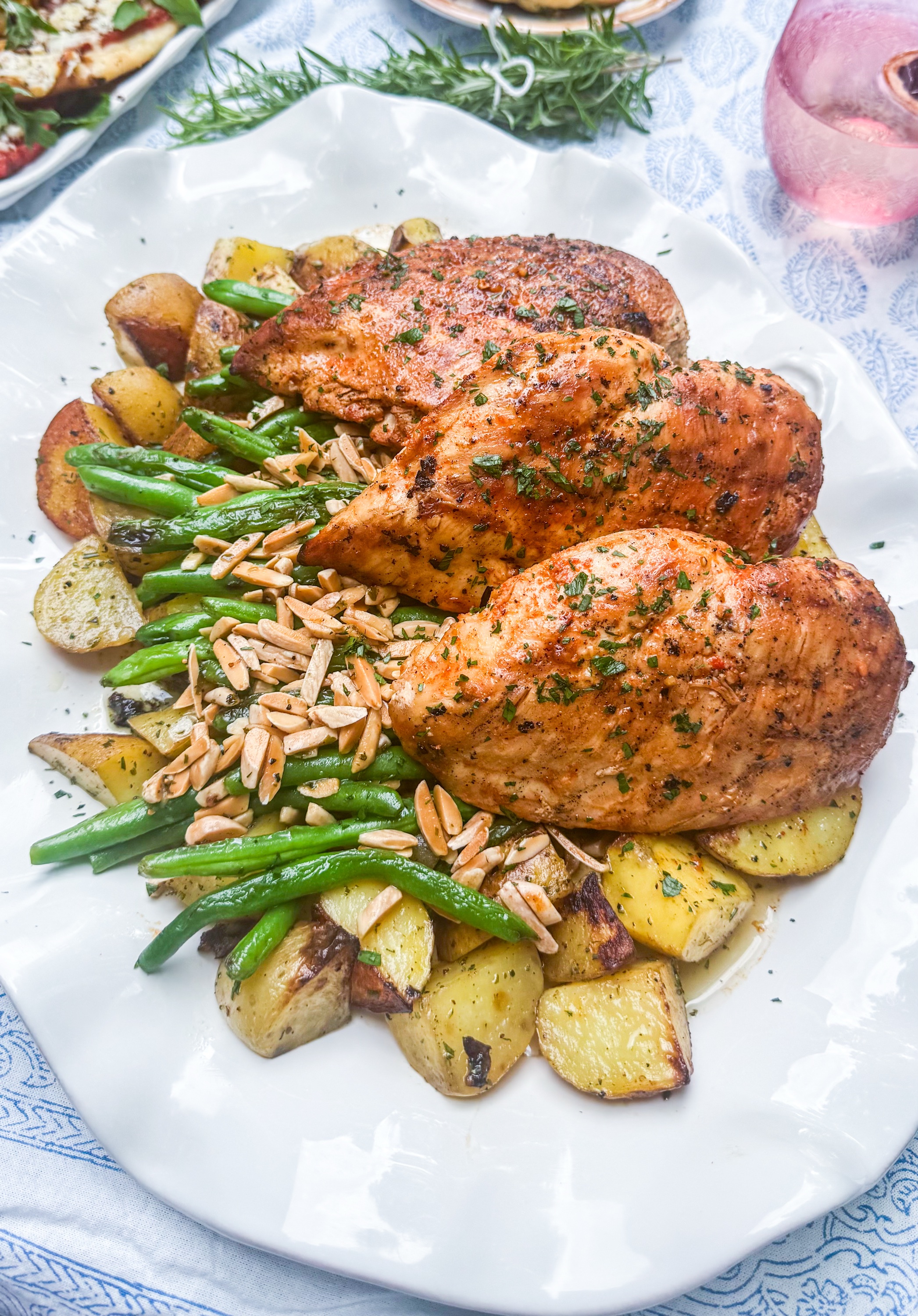 Steakhouse Garlic Marinated Chicken - Steakhouse marinated grilled chicken with roasted rosemary potatoes, green beans with slivered almonds, and herb compound butter