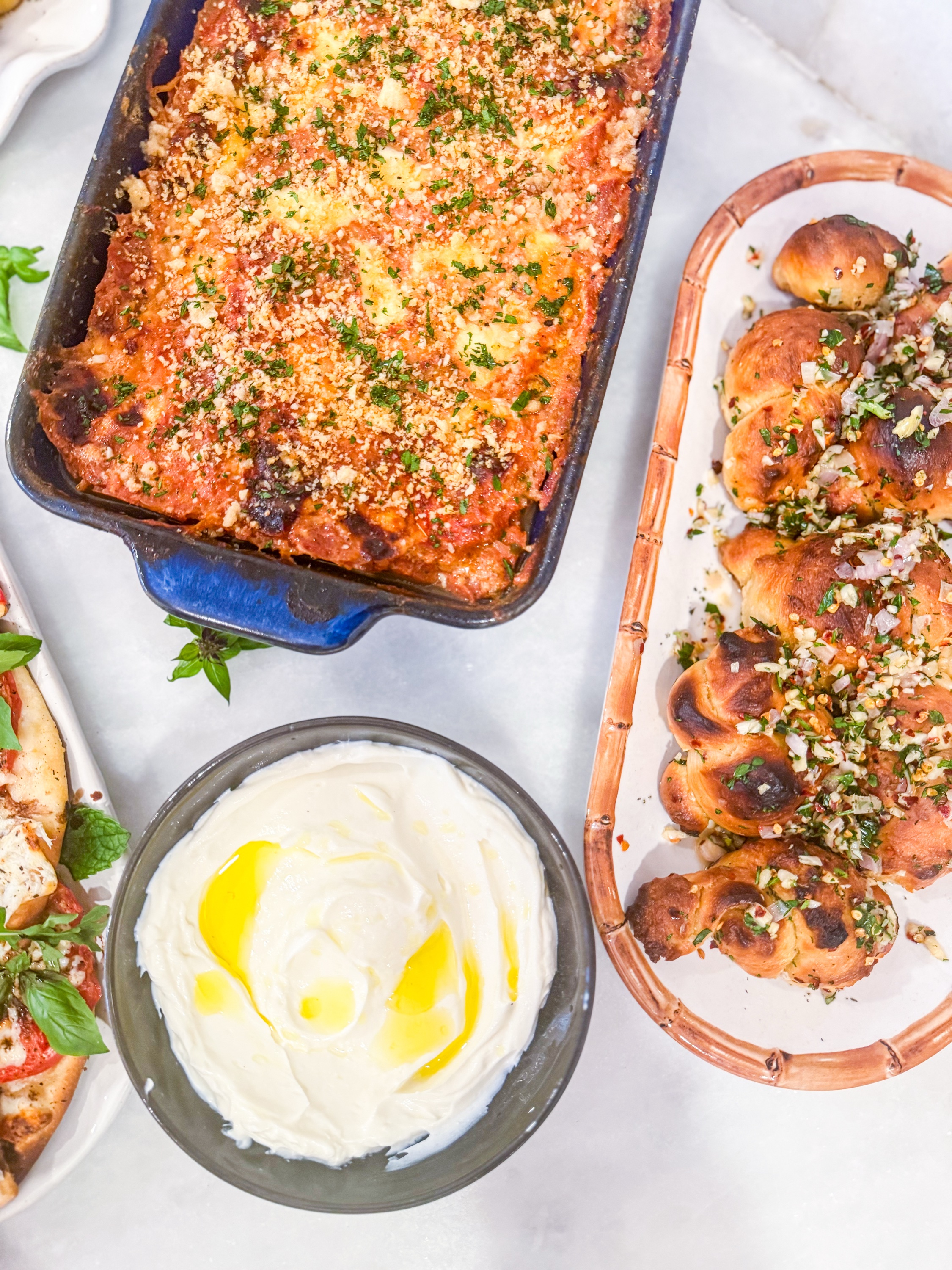 Eggplant Stack Bake - Layers of eggplant, breadcrumbs, roasted garlic tomato sauce, mozzarella, pecorino, and oregano served with house made garlic knots and whipped ricotta