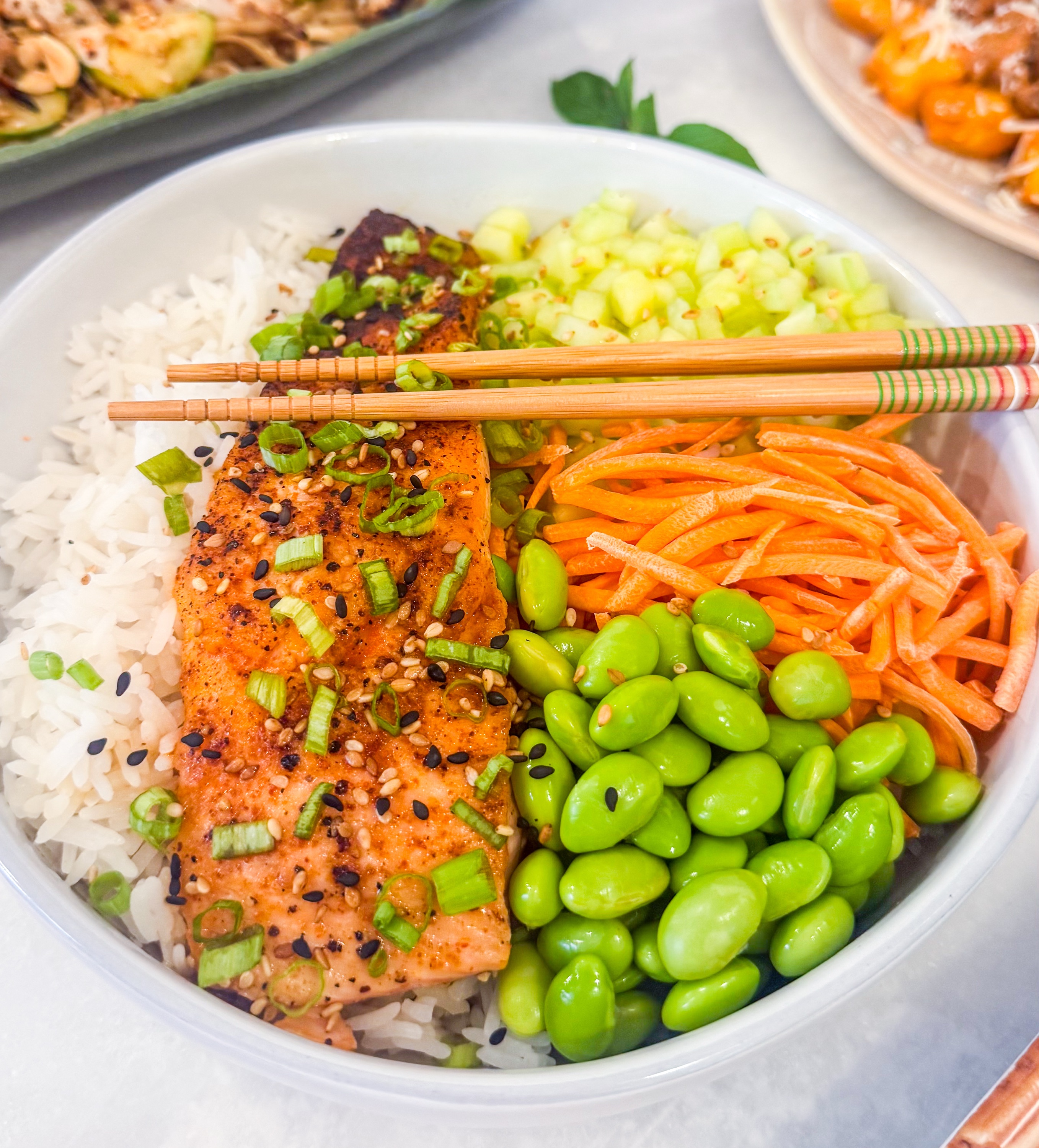 Hot Honey Salmon Bowl - Hot honey glazed salmon over jasmine rice with cucumber, edamame, shredded carrots, scallions and sesame seeds, served with sriracha lime mayo