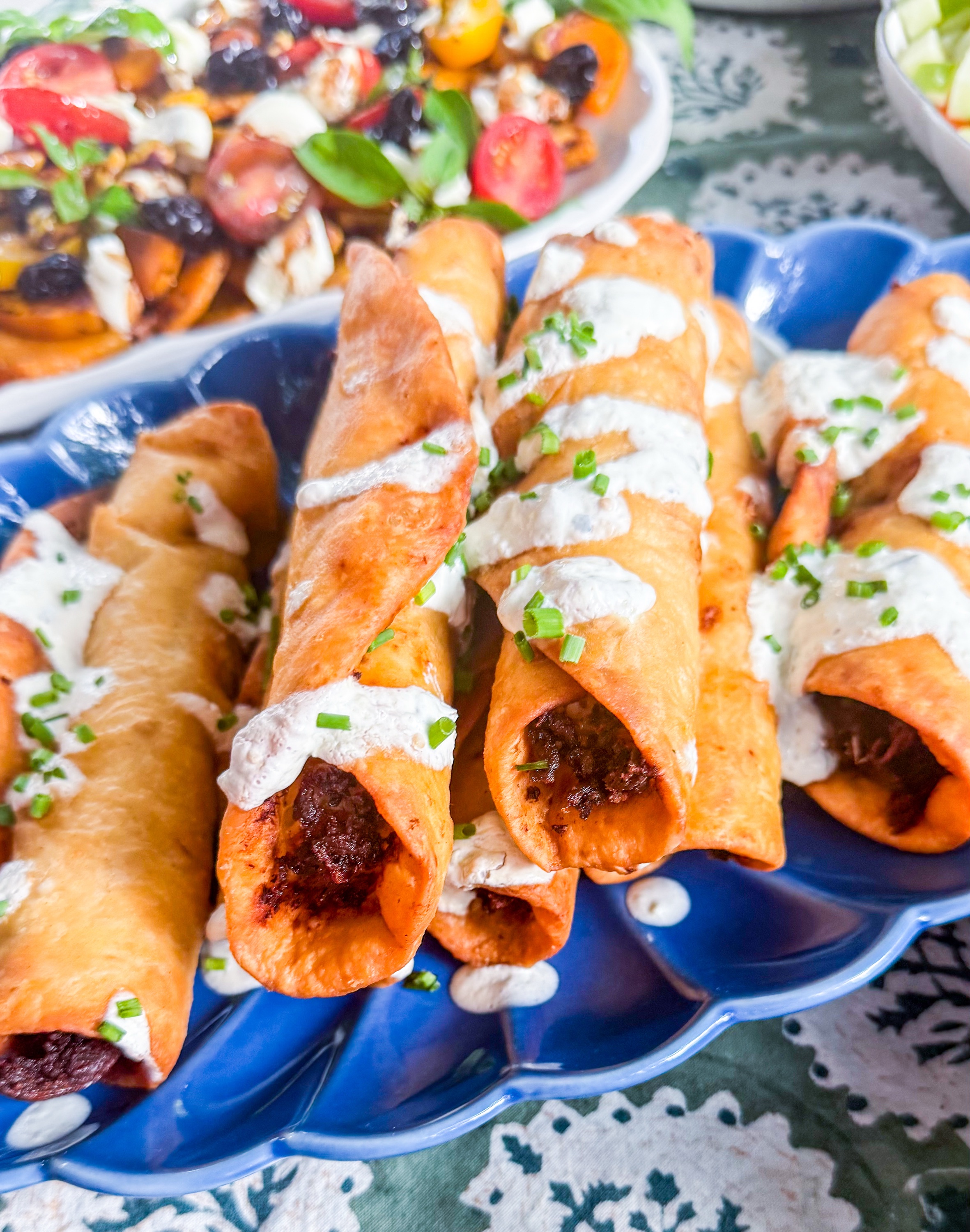 Green Chile Chicken Taquitos - Crispy taquitos filled with chicken, roasted green chiles and queso served with salsa verde sour cream