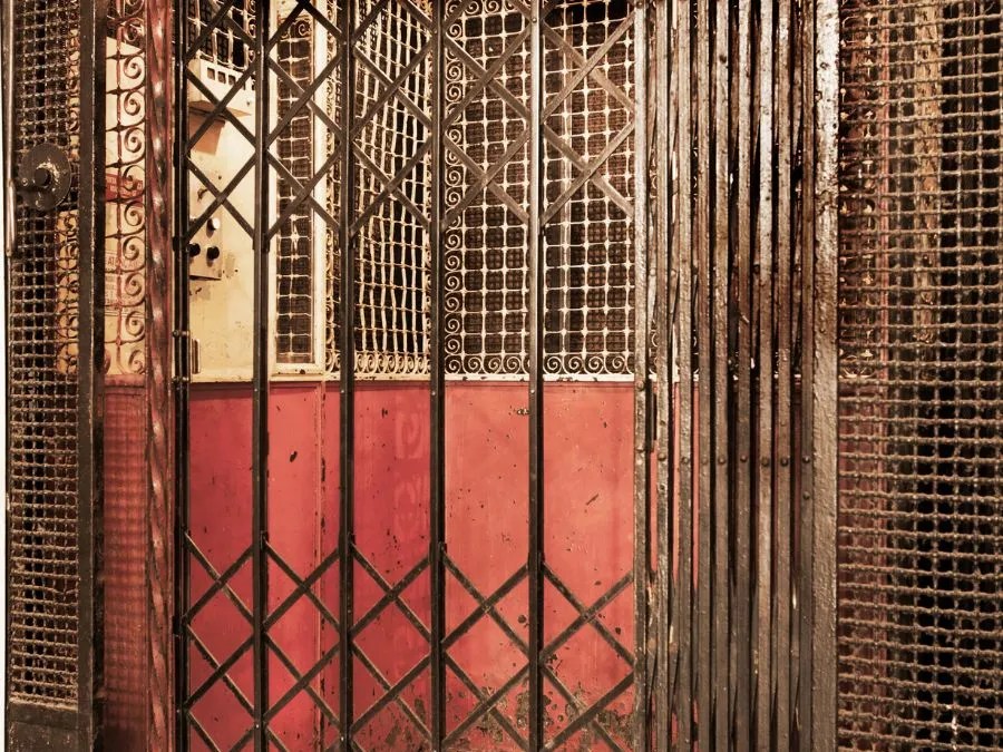 Vintage elevator doors symbolizing the evolution from early mechanical systems to modern elevator modernization