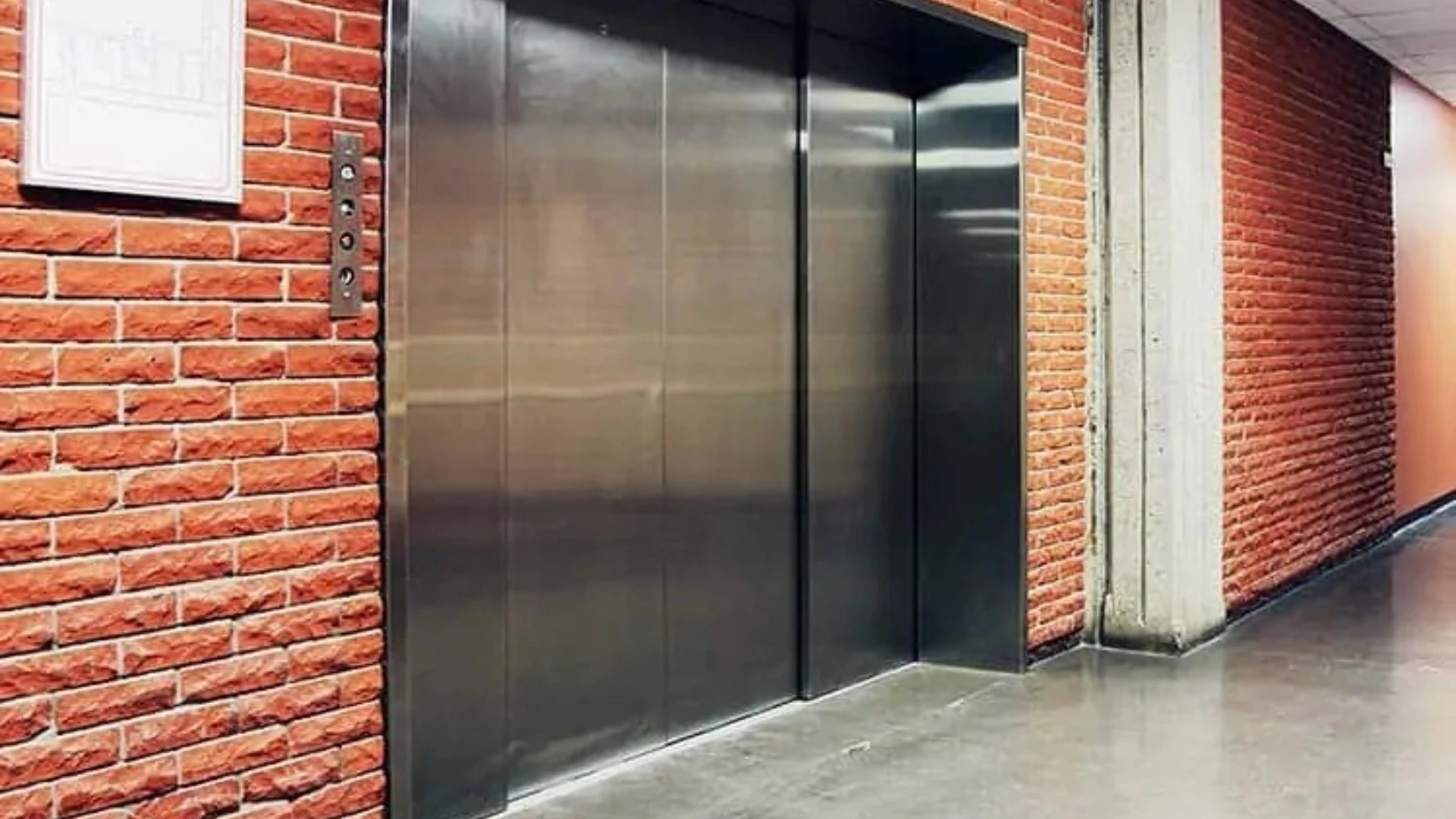 Modernized school elevator with stainless steel doors in an educational building, illustrating elevator modernization during school breaks.