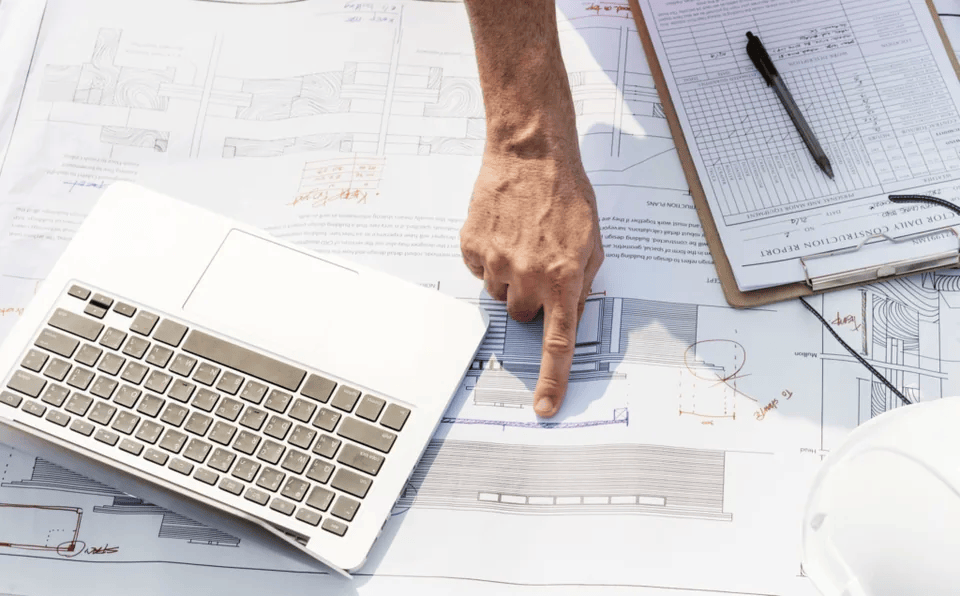 Plans, measurements and a laptop arranged for estimate preparation.