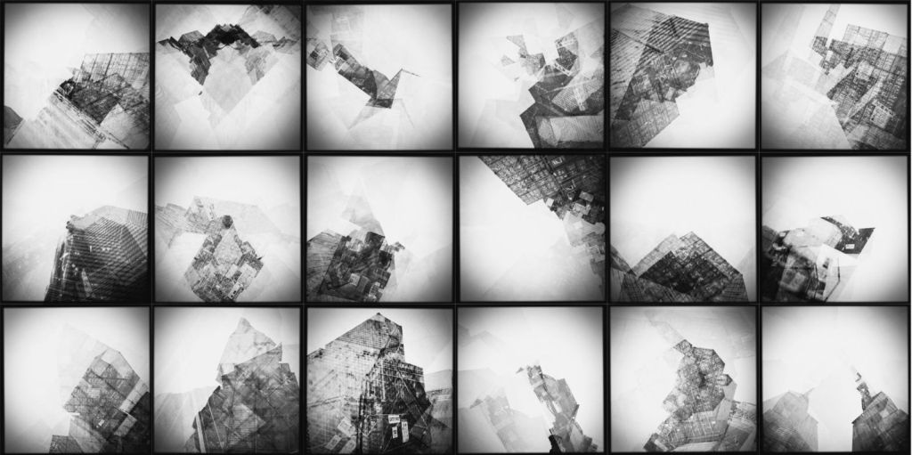 Black-and-white grid of eighteen altered photographs of shipping containers and industrial structures, fragmented through repeated in-camera exposures into layered geometric forms with a faint suggestion of a world map.