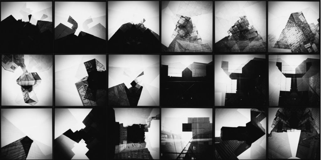 Black-and-white grid of eighteen altered photographs of shipping containers and industrial structures, transformed through repeated exposures into layered geometric forms with subtle echoes of pyramids, mountains and dark monumental shapes.