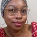 brown skin woman wearing glasses and lip gloss and a headwrap