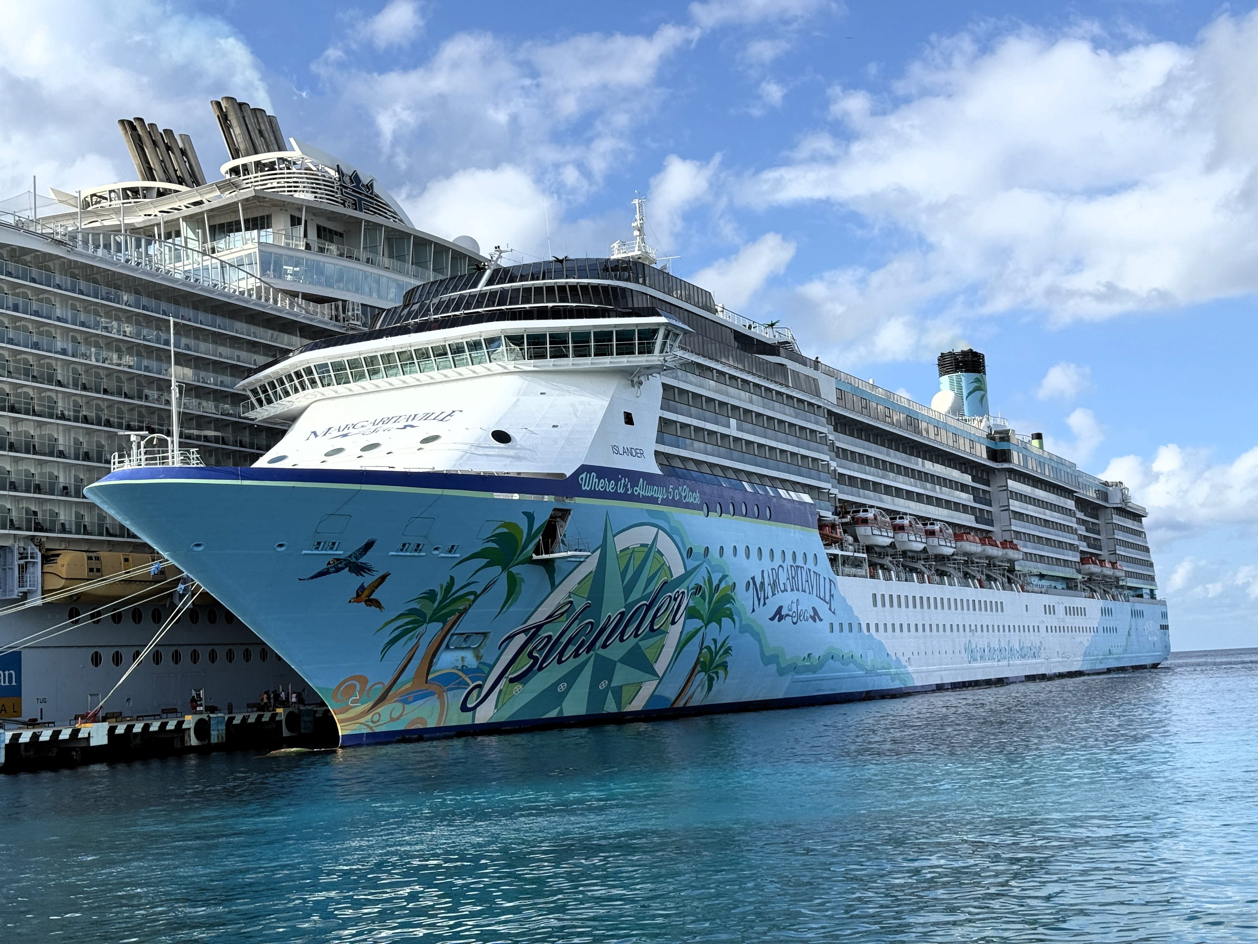 Large cruise ship, the front is painted with palm trees, and the script reads Islander.