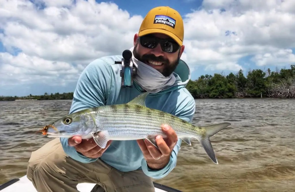 Captain James holding a bonefish caught on fly.