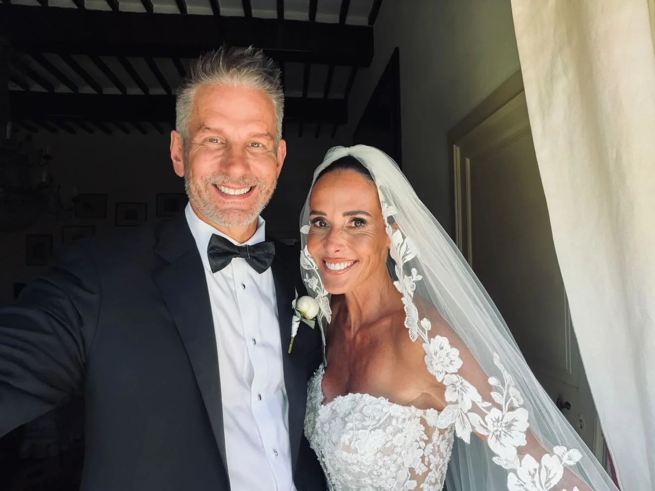 Bride and groom smiling together in a wedding selfie