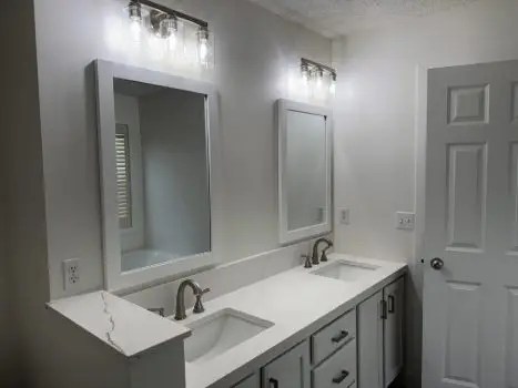 A new white double vanity with two white mirrors