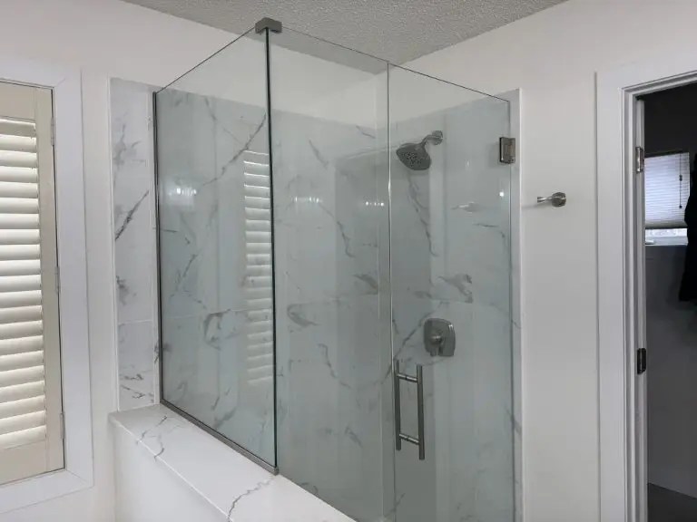 A brand new walk in shower with tile walls and custom glass