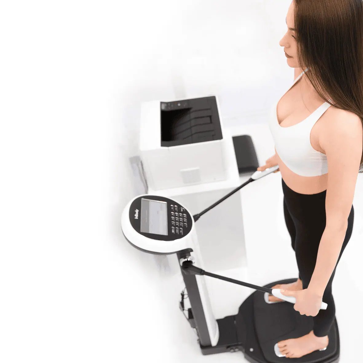 Person standing on an InBody body composition analyzer and holding its hand electrodes