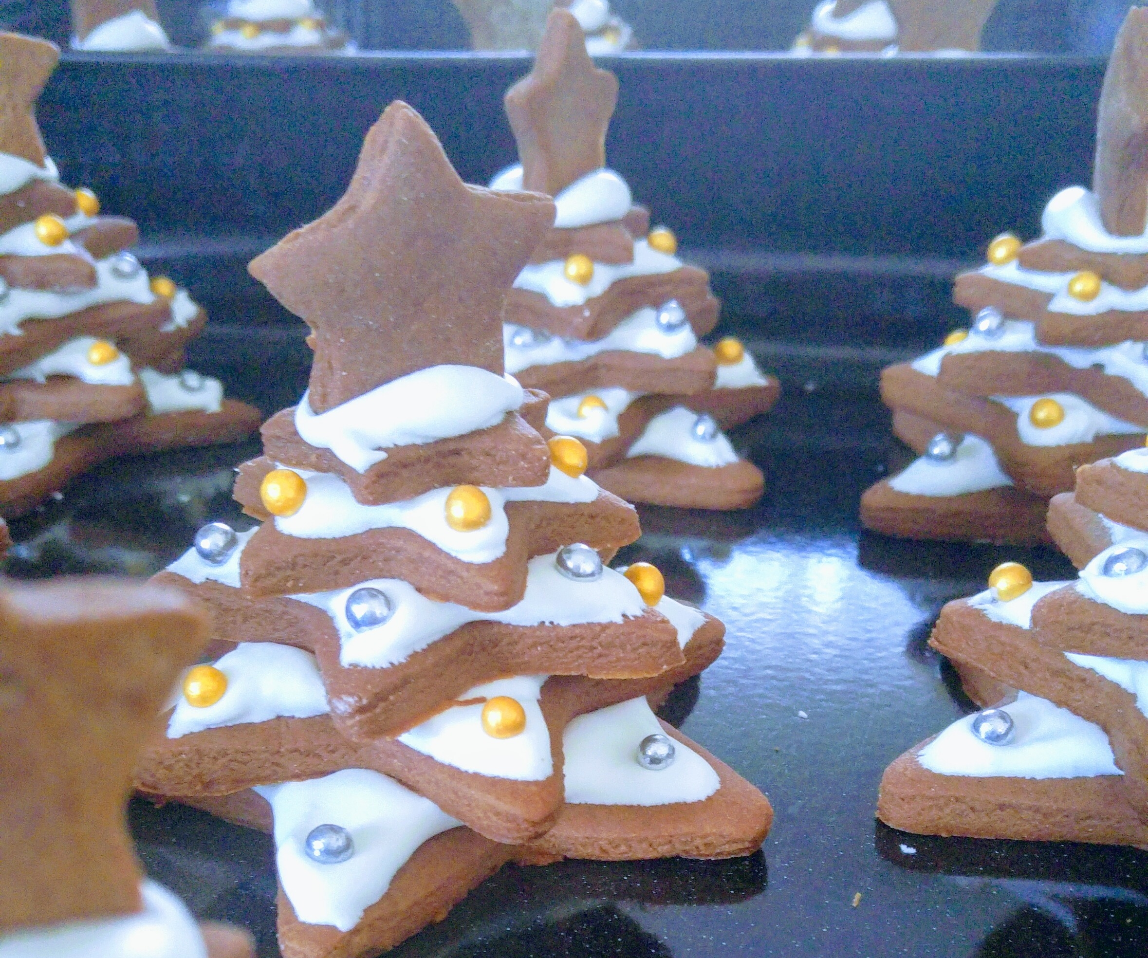 A few completed Gingerbread Christmas trees decorated with icing and sprinkles