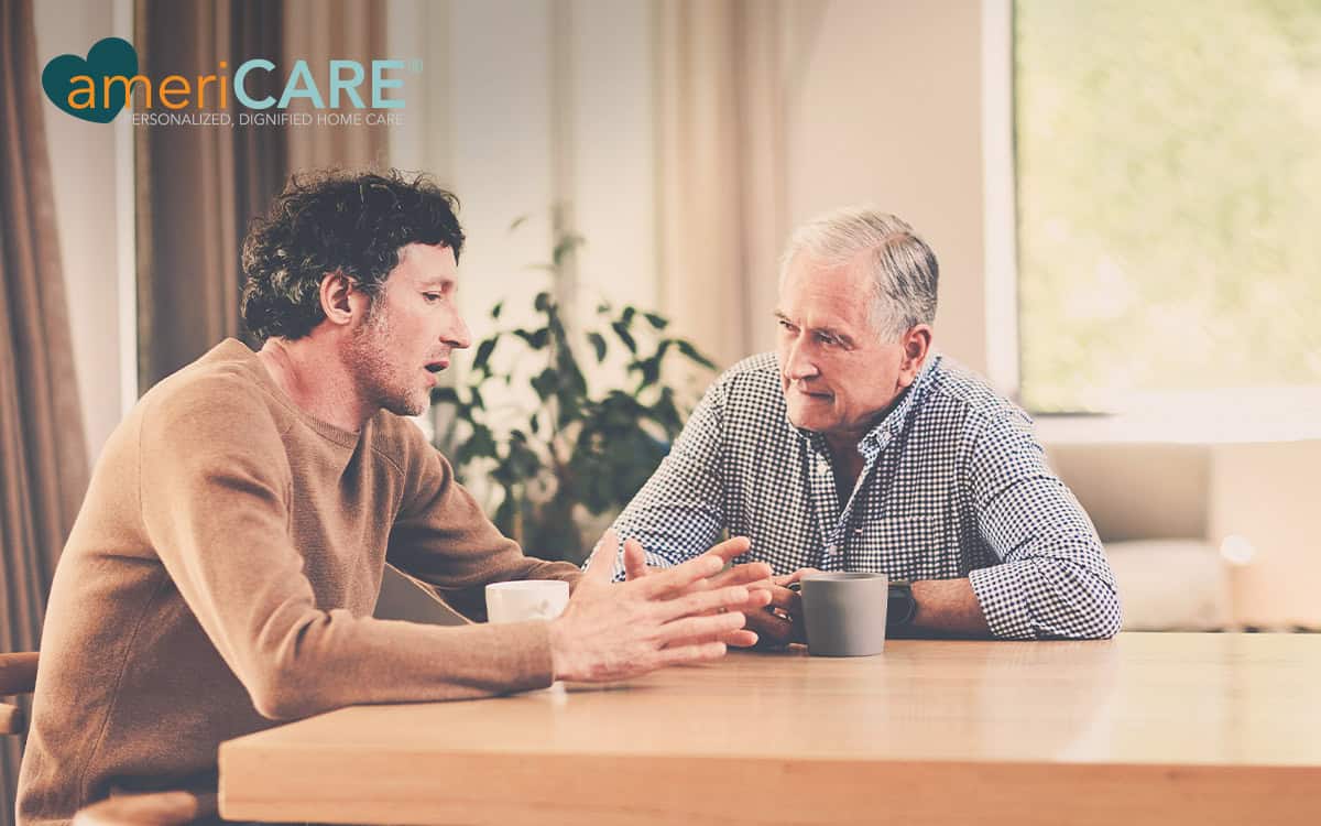Adult son talking with father over coffee