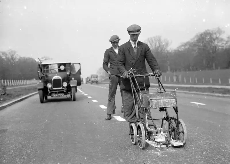 Men using a road marking machine.