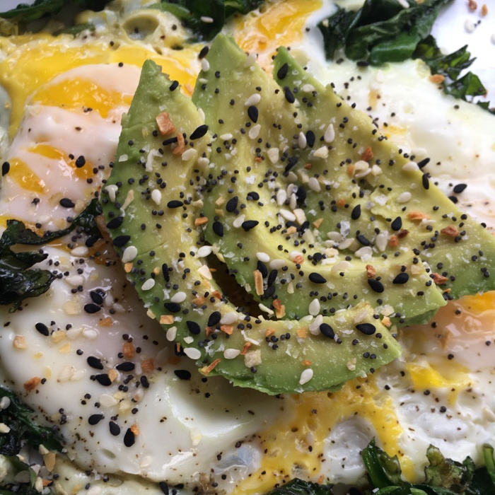 egg and spinach topped with avocado slices