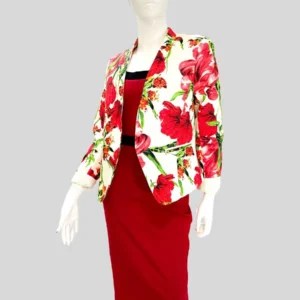 Francisca vistiendo un blazer con estampado floral en tonos rojos y verdes sobre fondo blanco. Diseño de corte estructurado con solapas clásicas, mangas largas arremangadas y ajuste perfecto para un look elegante y femenino. Ideal para elevar cualquier outfit con un toque de frescura y sofisticación.