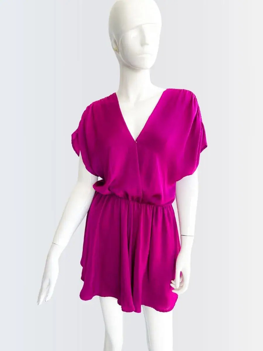 Romper fucsia sin mangas con escote cruzado y corte suelto, modelado por Francisca sobre fondo rosado suave.