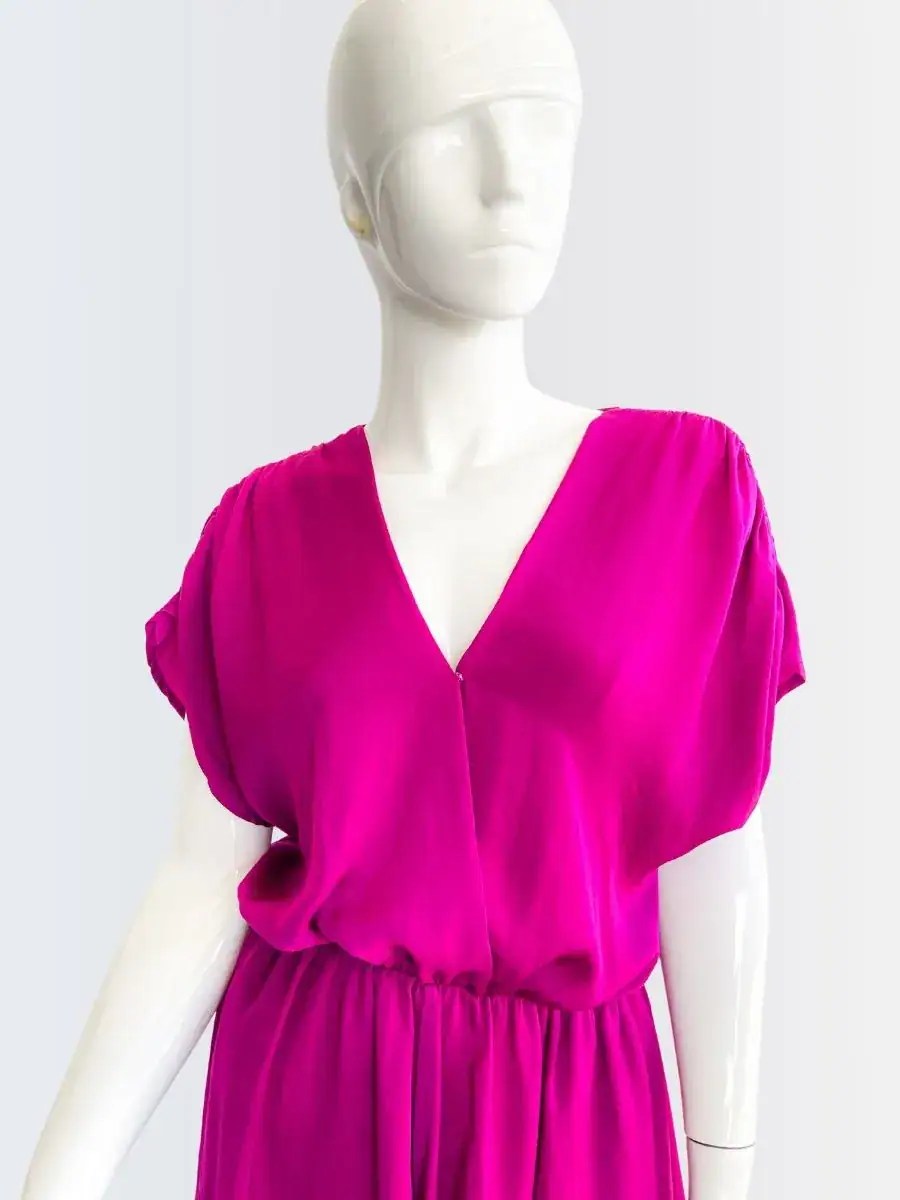 Romper fucsia sin mangas con escote cruzado y corte suelto, modelado por Francisca sobre fondo rosado suave.