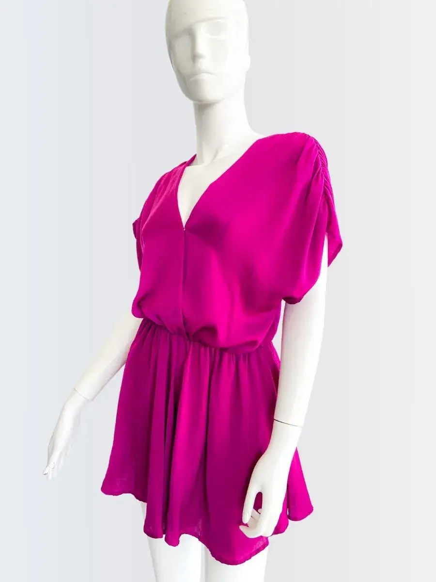 Romper fucsia sin mangas con escote cruzado y corte suelto, modelado por Francisca sobre fondo rosado suave.