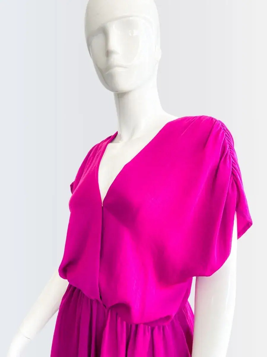 Romper fucsia sin mangas con escote cruzado y corte suelto, modelado por Francisca sobre fondo rosado suave.