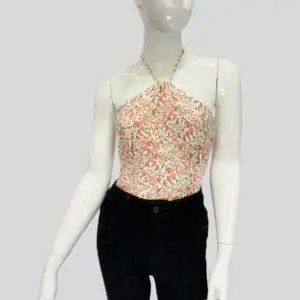 Top floral estilo halter con escote amarrado al cuello, en tonos coral y verde sobre fondo blanco, ideal para outfits frescos y femeninos.