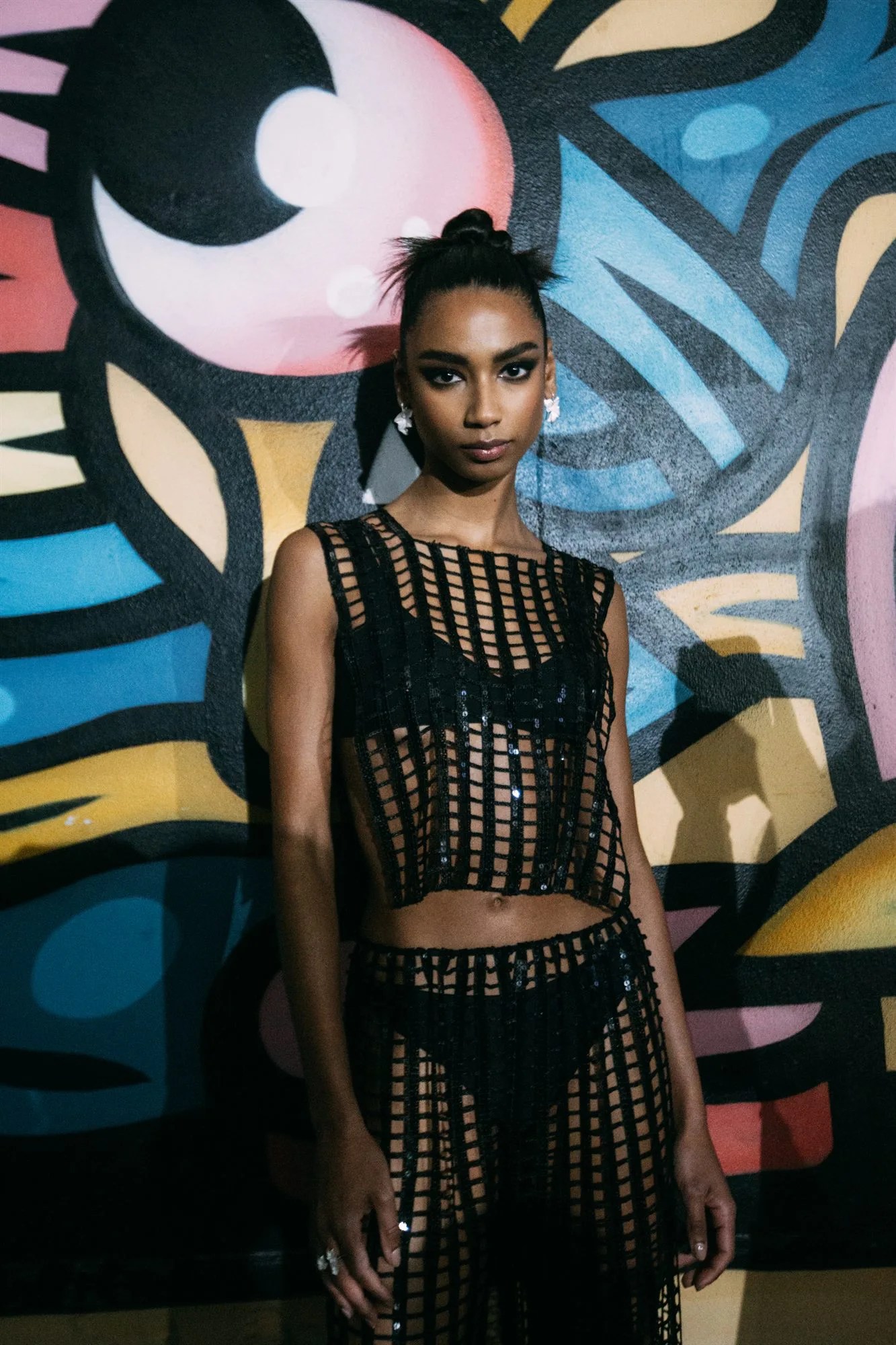 Chignon alto, modella davanti a un murale