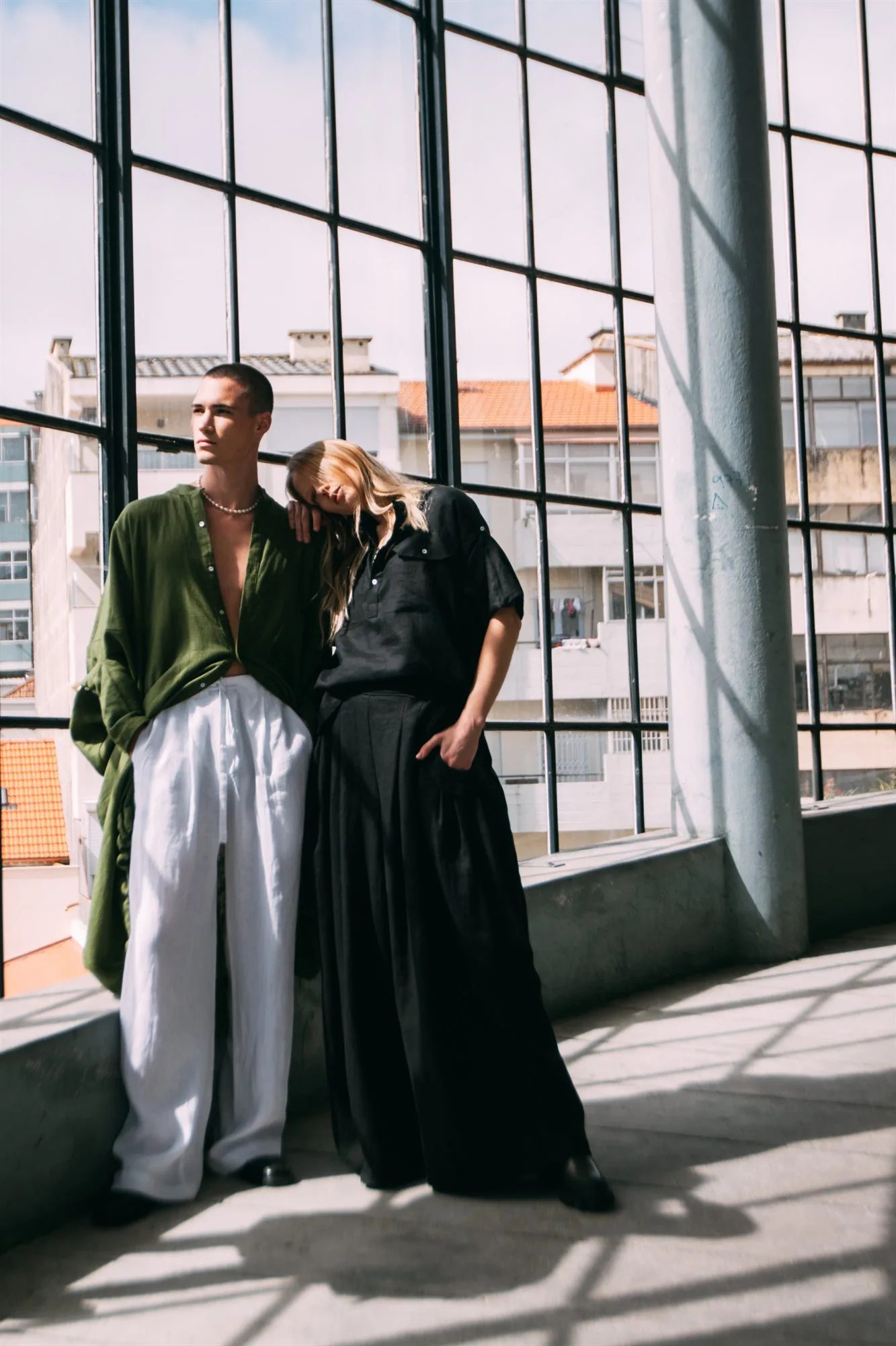 Due modelli nel backstage accanto alla vetrata