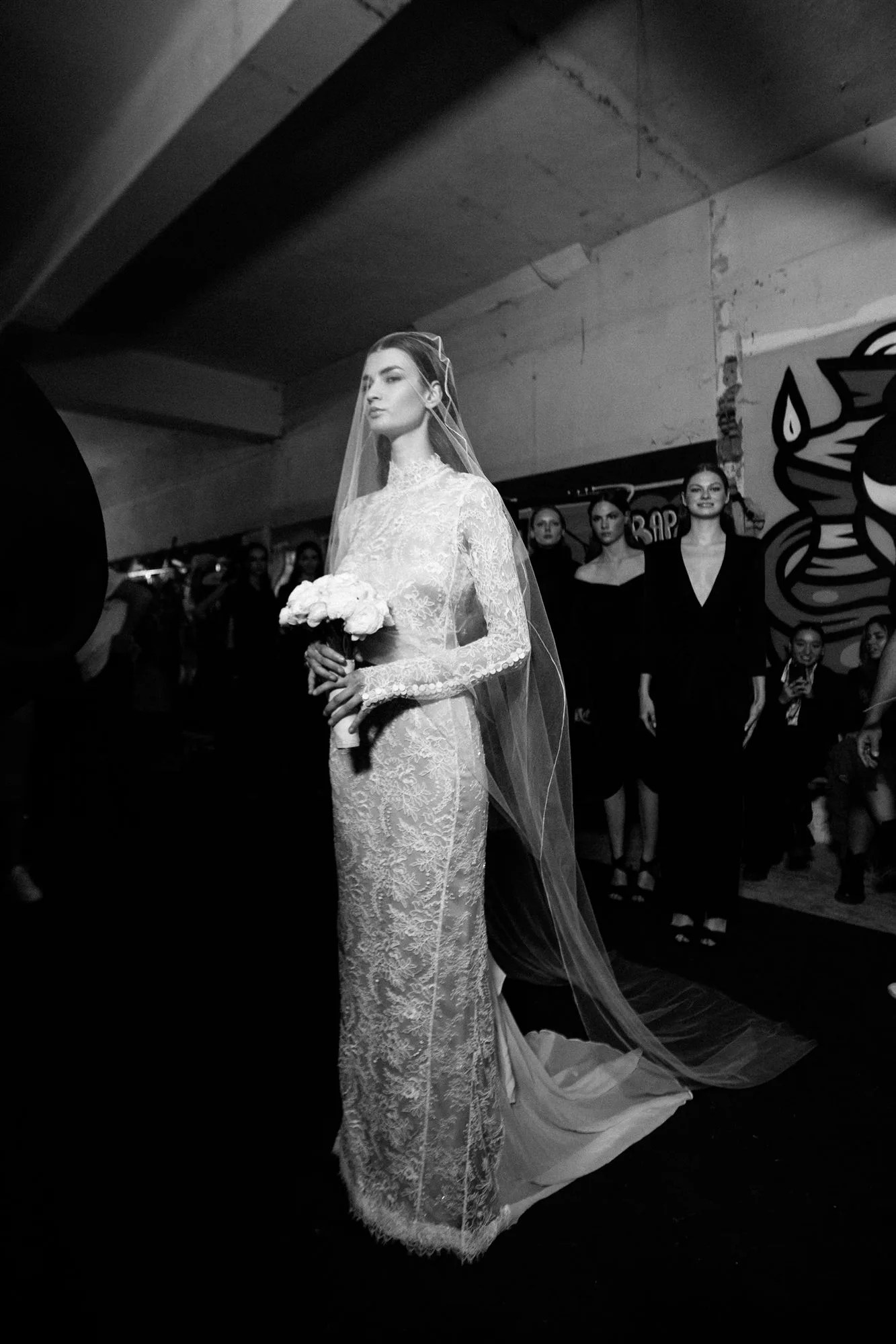 Sposa con abito in pizzo e velo in passerella